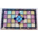 A multi-coloured stained glass window panel of geometric design with central boss - 32 1/2" x 19"