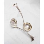 A pair of late Victorian silver sauce ladles with shell pattern bowls and ornate scroll terminals by
