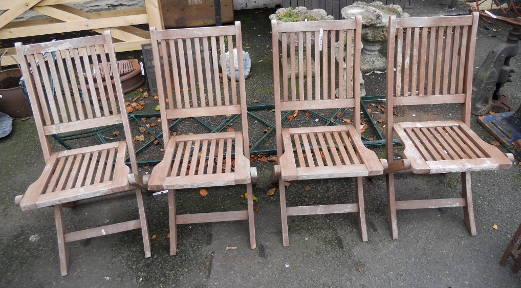 A set of four teak folding garden chairs with slatted seats and backs