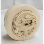 A late 19th Century circular ivory box with carved dragon detail to lid