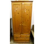 A 32" modern polished pine wardrobe with hanging space enclosed by a pair of panelled doors, over