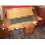 An oak kneehole leather top writing desk with lift-top pull-out mechanism