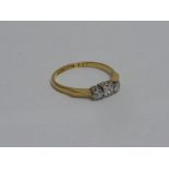 AN 18CT GOLD DIAMOND RING, the central b