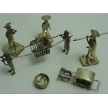 A GROUP OF NOVELTY ORIENTAL WHITE METAL ORNAMENTS, to include a sedan chair, three figures wearing