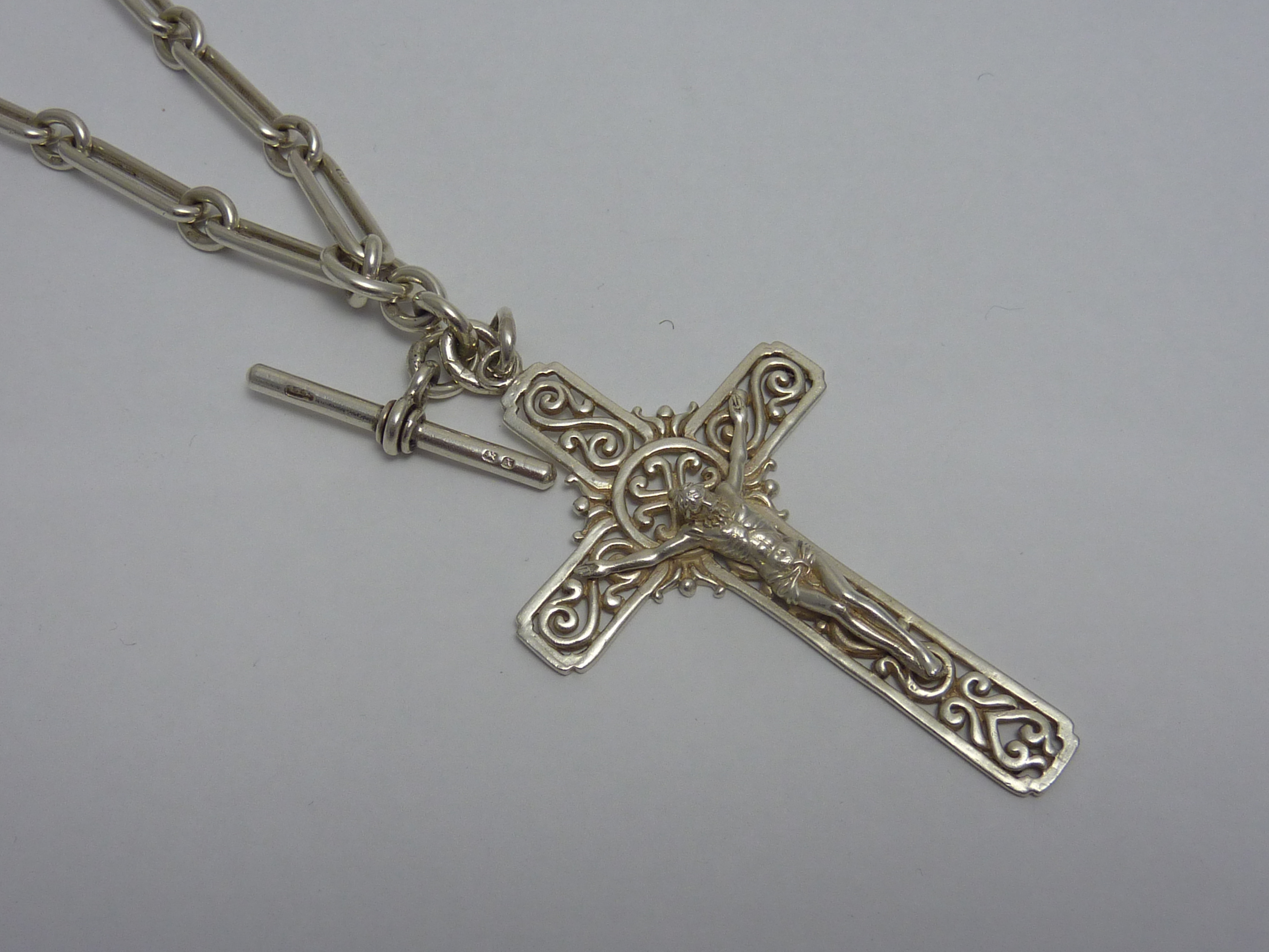 A LARGE SILVER CRUCIFIX PENDANT AND CHAI