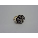 A 9CT GOLD CLUSTER RING, of flower shape design with diamond and sapphire, hallmarks