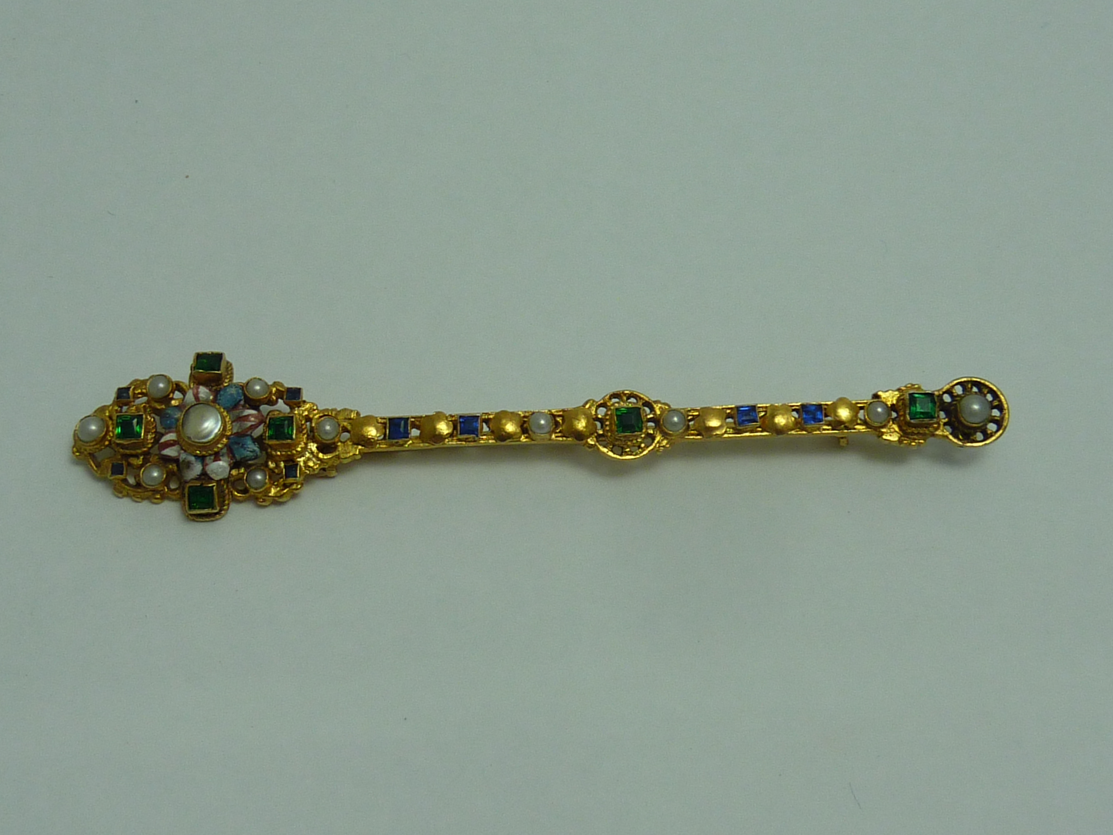 A RUSSIAN GILT METAL PIN, with gem set and seed pearl detail, with enamel detail, marks to pin