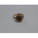 A VICTORIAN RING, the central circular amethyst with decorative scalloped surround