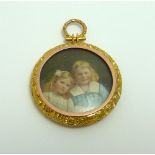 AN EARLY 20TH CENTURY PICTURE LOCKET, depicting two children within a scrolling floral surround to