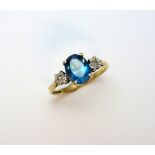 A 9CT GOLD TOPAZ AND DIAMOND RING, with oval shape topaz flanked by rose cut diamonds, hallmarks for