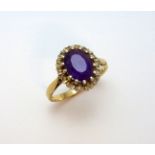 A 9CT GOLD AMETHYST AND DIAMOND RING, the oval amethyst within a surround of diamond accents, to the