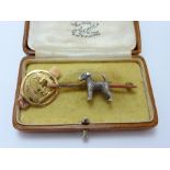 TWO BROOCHES, the first a dog on a bar, the second a small circular brooch with three animals