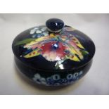 A MOORCROFT POTTERY POWDER BOWL AND COVER, Orchid design on blue ground, paper label, diameter 11.