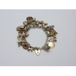 A VINTAGE CHARM BRACELET, comprising of nineteen various charms with heart shape padlock clasp,