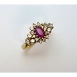 A 9CT GOLD RUBY AND DIAMOND RING, the central oval ruby within a surround of mixed cut diamonds