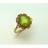 A 9CT GOLD PERIDOT RING, the oval shape peridot within a rope twist surround to the tri pronged