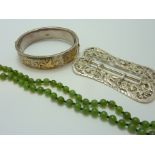 THREE ITEMS, to include a decorative silver belt buckle, a string of jade beads and a silver and