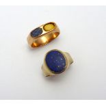 TWO LAPIS LAZULI RINGS, the first designed as a signet ring, the second as two oblong shape panels