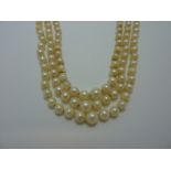 A TRIPLE STRAND OF GRADUATED PEARLS, with bow shape paste clasp (s.d.)