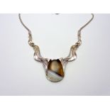 A NECKLACE, with central chalcedony stone and white metal abstract shaped flanked links