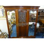 AN EDWARDIAN CARVED MAHOGANY TRIPLE DOOR COMPACTUM WARDROBE, the central solid door revealing