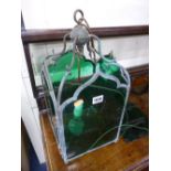 AN EARLY 20TH CENTURY HANGING LANTERN, with green glass panels (one panel broken)