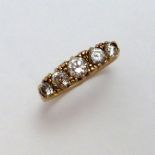 A 9CT GOLD DIAMOND RING, with five graduated diamonds to the scrolling tapered band, hallmarks for