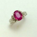 A 9CT GOLD RUBY RING, the oval ruby with single cut diamond details to the sides to the tapered