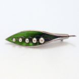 A SILVER BROOCH, of leaf shape with green enamel detail, depicting a Lily-of-the-valley, hallmarks