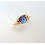 A SAPPHIRE AND DIAMOND RING, the oval shape cornflower blue sapphire flanked by brilliant cut
