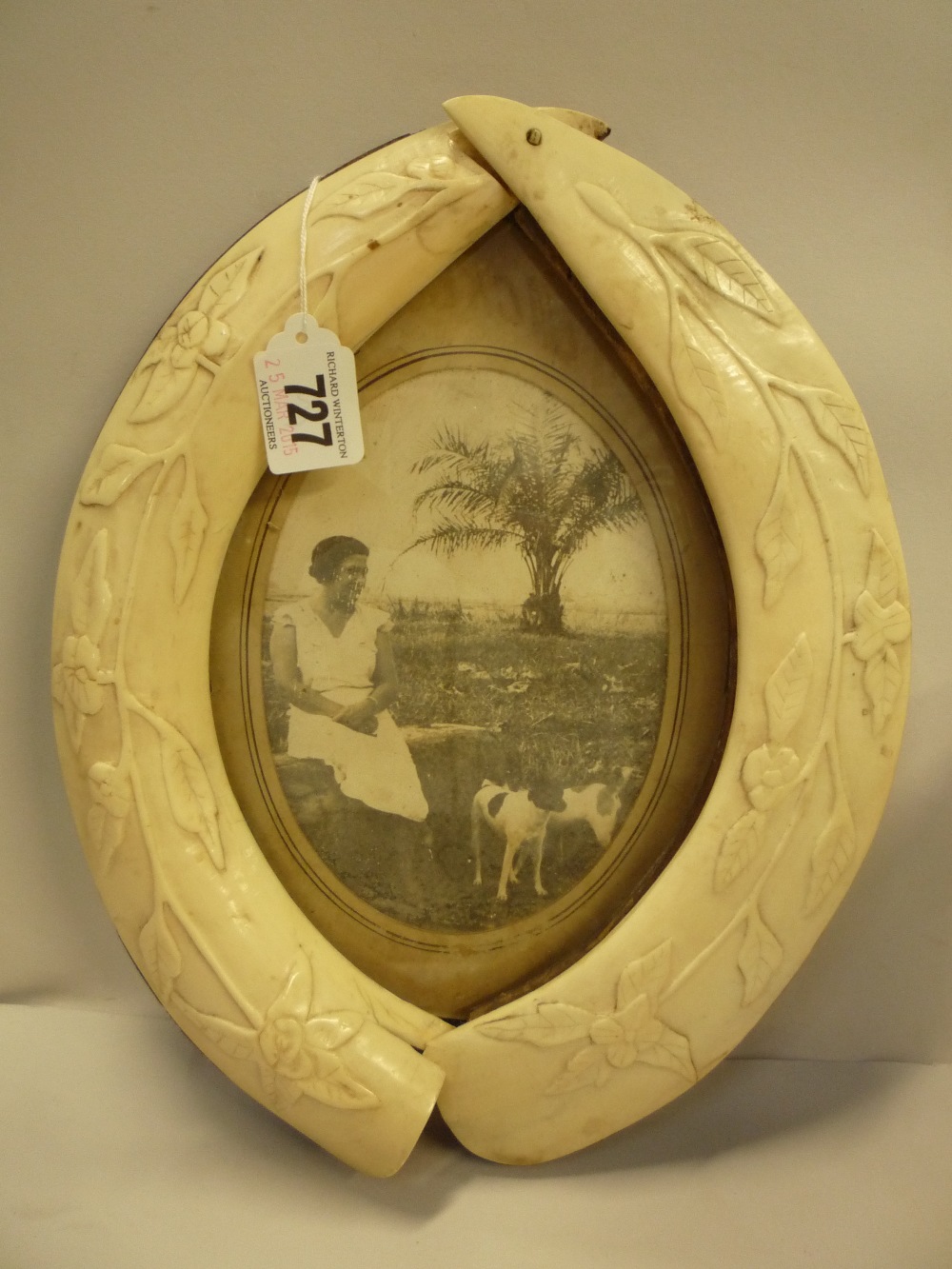 A 1920'S PHOTO FRAME, framed by two carved ivory tusks