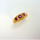 AN 18CT GOLD RUBY AND DIAMOND RING, with three rubies and old cut diamond accents, with engraved