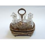 A GEORGE IV SILVER AND GLASS CONDIMENT SET, London 1824 of boat shape with moulded ring handle on