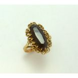 A 9CT GOLD SMOKEY QUARTZ RING, the elongated oval smokey quartz within a scalloped surround, ring