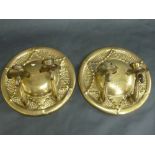 A PAIR OF PRESSED AND MOULDED BRASS ARTS & CRAFTS CANDLE SCONCES, the circular back plates moulded