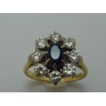 AN 18CT GOLD SAPPHIRE AND DIAMOND RING, the oval shape sapphire within a surround of brilliant-cut