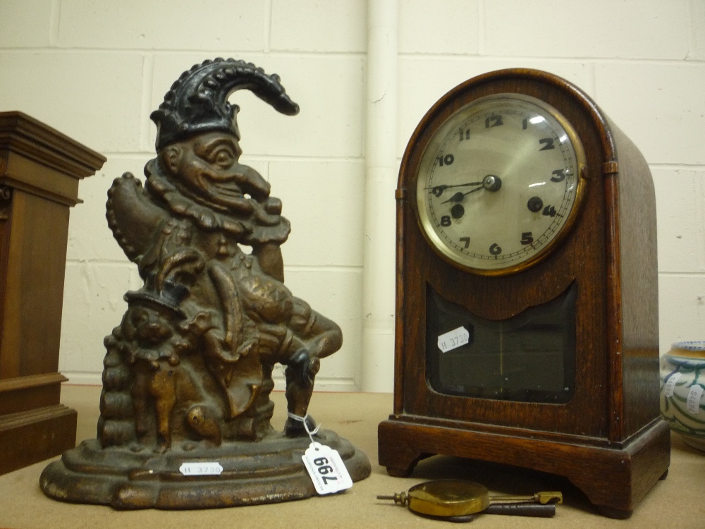 A CAST 'PUNCH' DOORSTOP, and a mantel clock (key and pendulum)