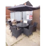 A RATTAN CIRCULAR GARDEN TABLE, with glass insert, six various chairs and a parasol with a marble