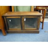 A WALNUT TWO DOOR DISPLAY CABINET, (situated in furniture room)