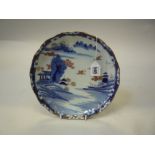 A JAPANESE IMARI DISH, Taisho period, of lobed shape and painted with riverscape, buildings and