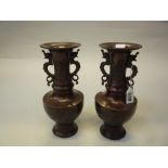 A PAIR OF JAPANESE BRONZE VASES, 20th Century, of balusters form with twin dragon handles,