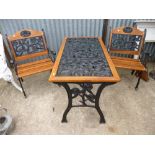 A CAST IRON GARDEN TABLE, and two slatted chairs with cast iron ends (3)