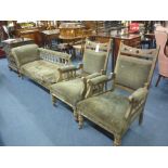 A LATE VICTORIAN OAK FRAMED UPHOLSTERED PARLOUR SET, comprising a chaise and two chairs, chaise