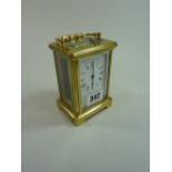 A BRASS FOUR PANE CARRIAGE CLOCK, with enamelled dial, 11cm excluding handle