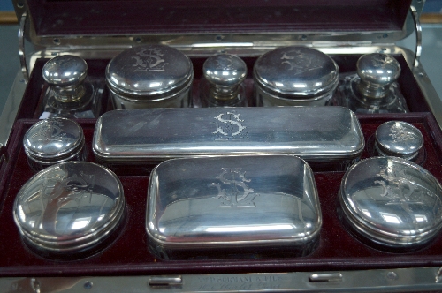 A CASED FRENCH GLASS AND SILVER MOUNTED TRAVELLING TOILET SET, by P. Sormani and Fils, with two lift