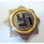 A 3RD REICH GERMAN GOLD CROSS MEDAL, with black enamel Swastika on a frosted silver ground, framed