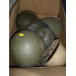 A BOX CONTAINING NINE MILITARY ISSUE STEEL HELMETS, WWII era and beyond, to include British,