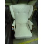 AN UPHOLSTERED WING BACK ARMCHAIR