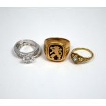 FOUR RINGS, the first a gentlemans ring with emblem of a lion, together with three further rings