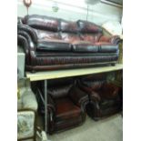 AN OX BLOOD LEATHER THREE PIECE SUITE, comprising of a three seater settee and a pair of armchairs
